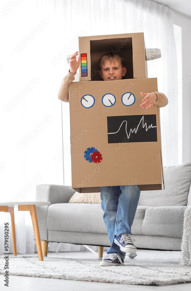 Little boy in cardboard robot costume playing at home