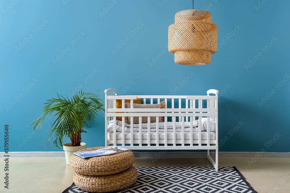 Interior of childrens bedroom with crib and poufs