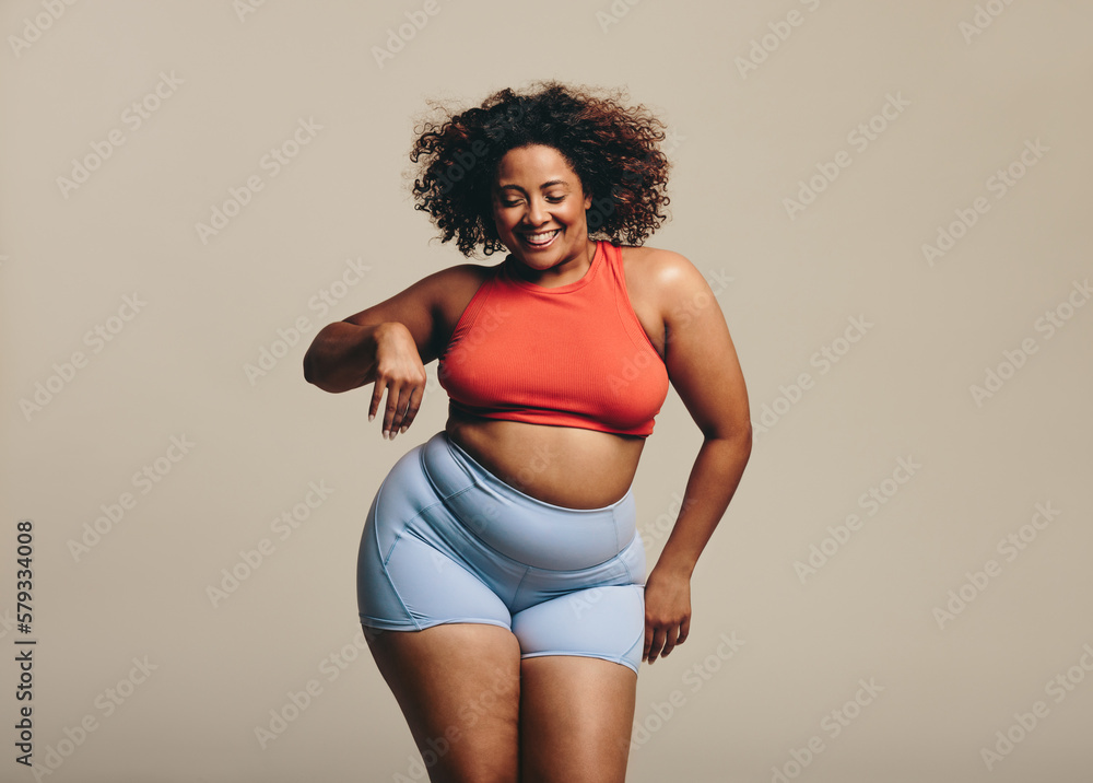 Woman celebrating body positivity and fitness in a studio