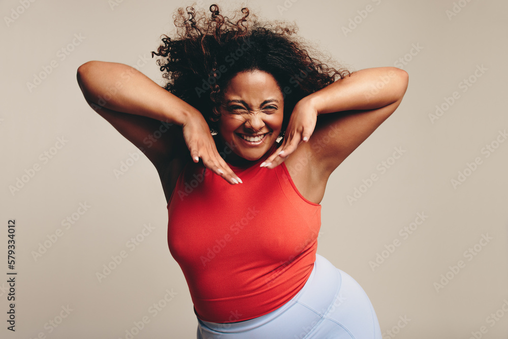 Excited woman moving her fit and curvy body in a fun dance workout