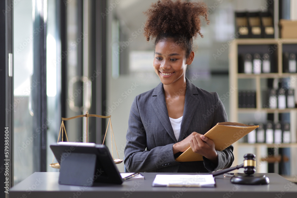 Female lawyer working on a desk in a law office.