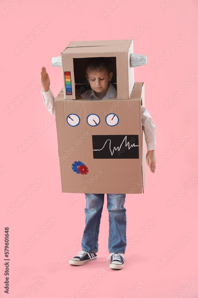 Little boy in cardboard robot costume on pink background