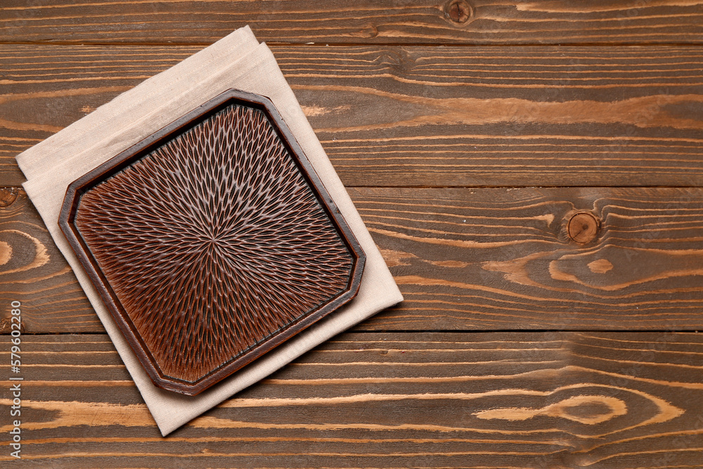 Stylish plate and napkin on wooden background