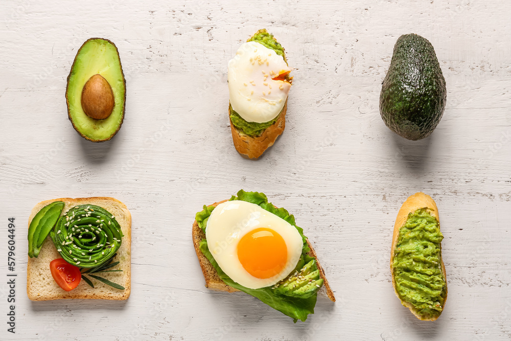 Different delicious avocado toasts on white background