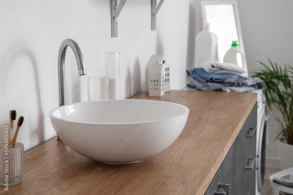 White sink on counter in light bathroom