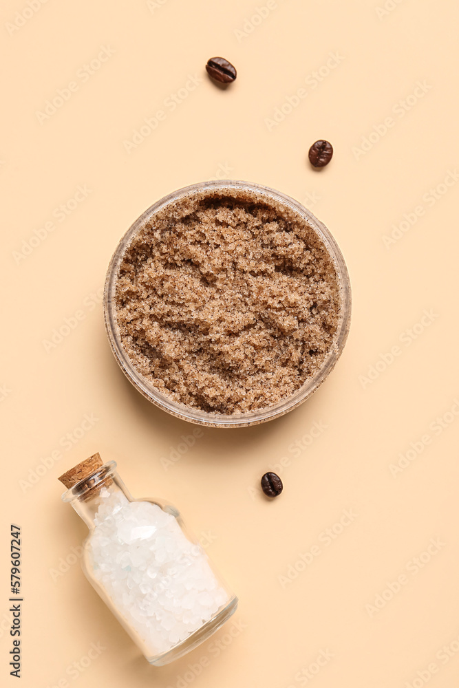 Jar with body scrub and bottle of sea salt on color background