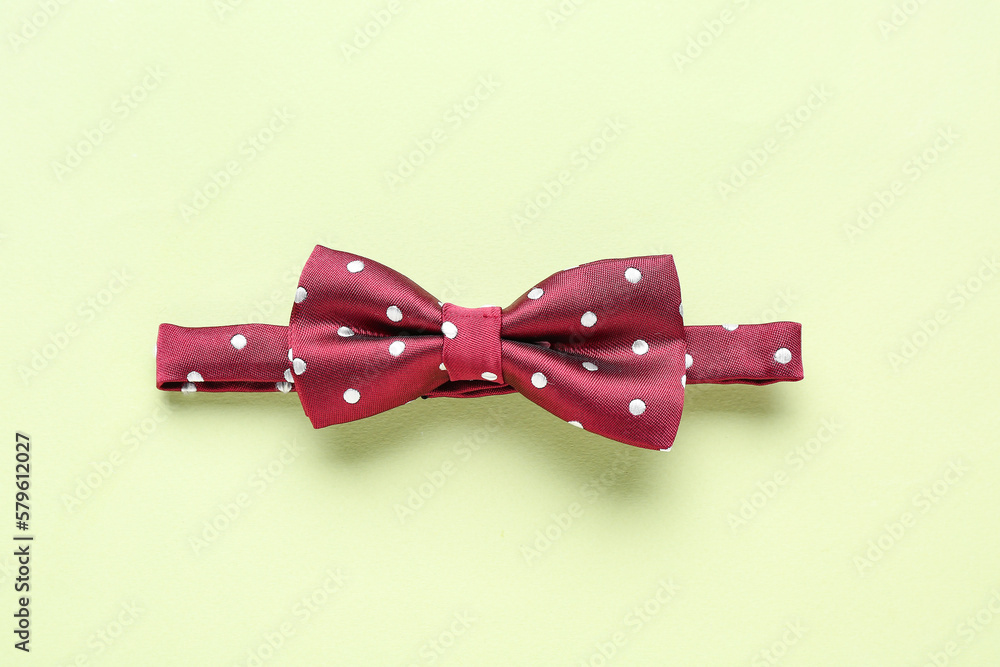 Stylish bow tie on color background