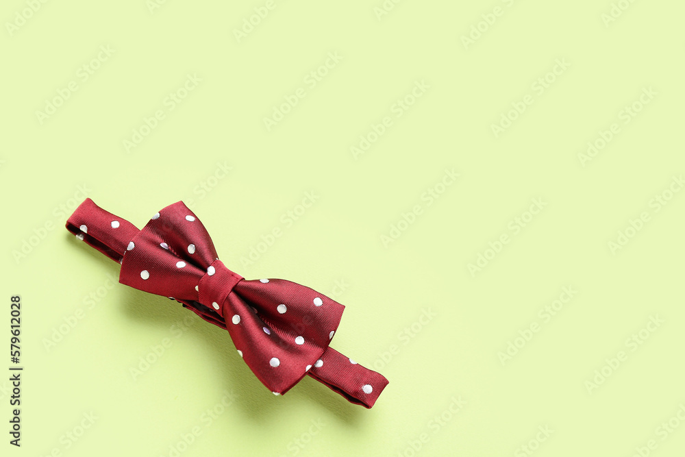 Stylish bow tie on color background