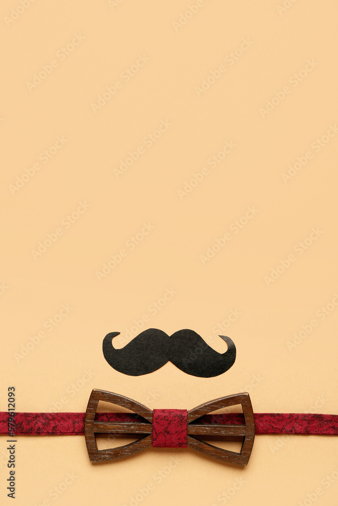 Composition with stylish wooden bow tie and paper mustache on color background