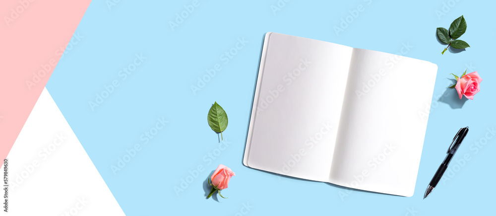 Open notebook or diary with a pen from above with rose buds- flat lay