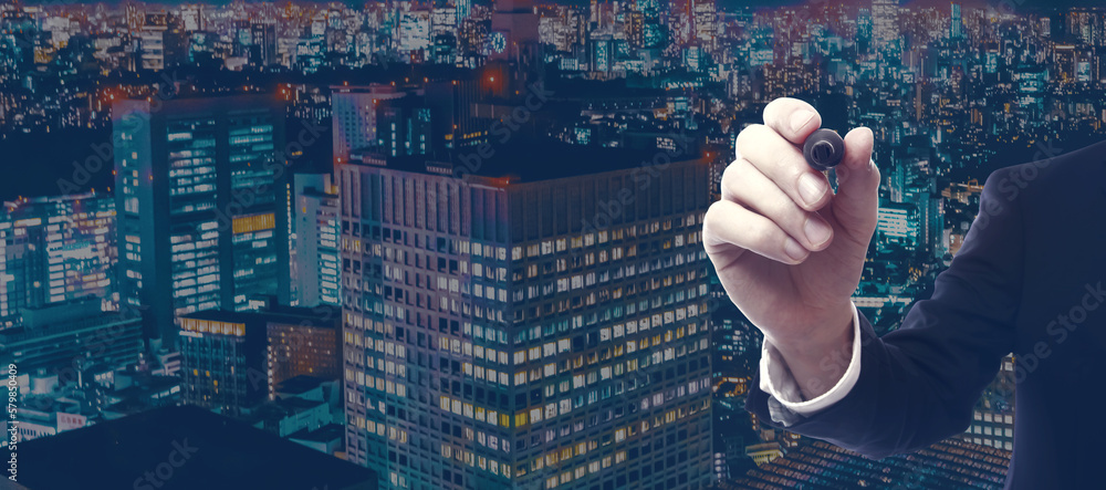 Businessman holding a marker in a city at night