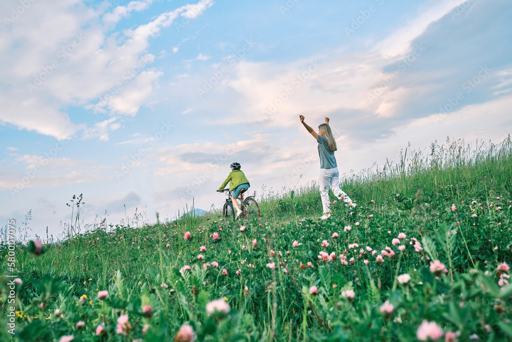 happy family outdoors, Mother teaching son to ride bicycle. Happy cute boy in helmet learn to riding