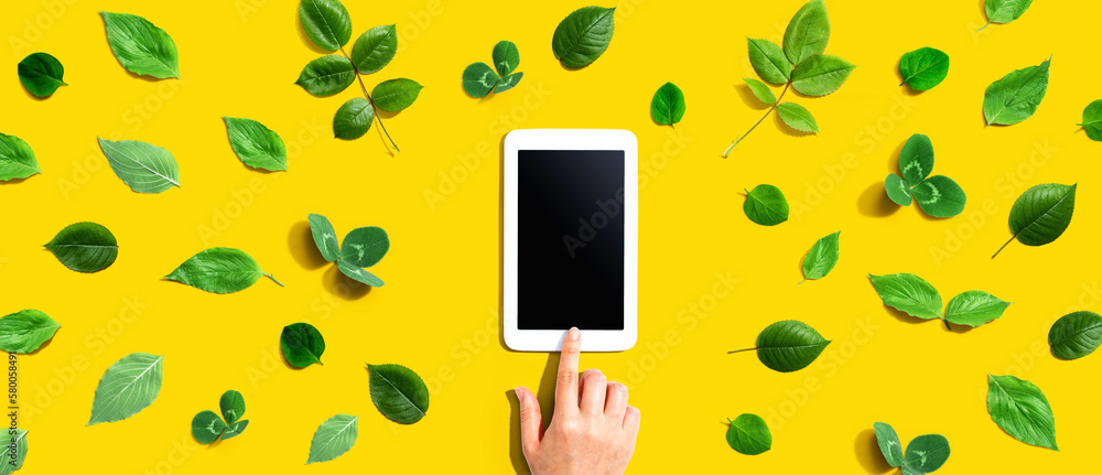 Green leaves with a tablet computer - flat lay