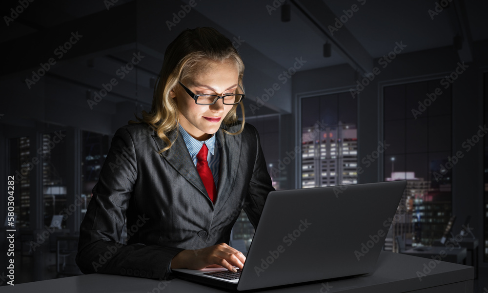 Charming businesswoman sitting at office desk