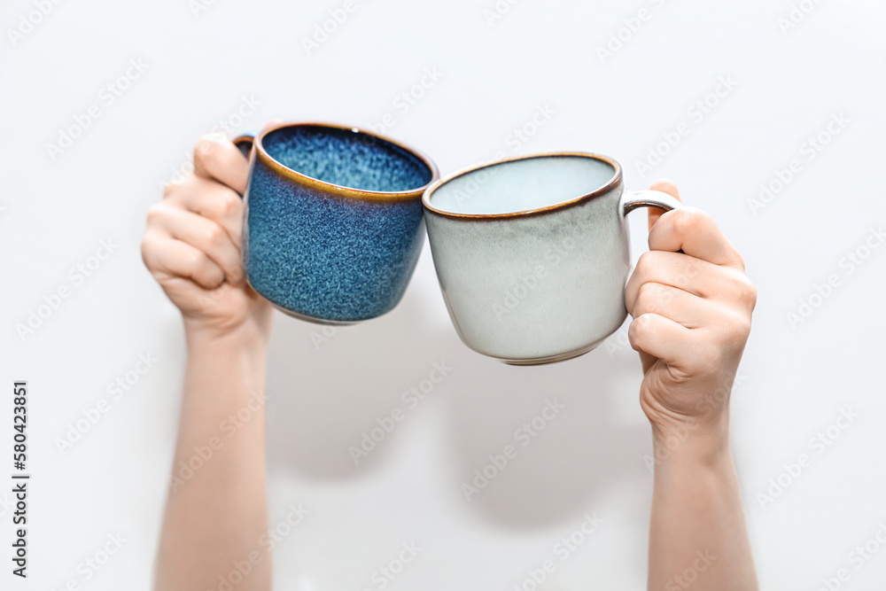 Woman holding different cups on grey background