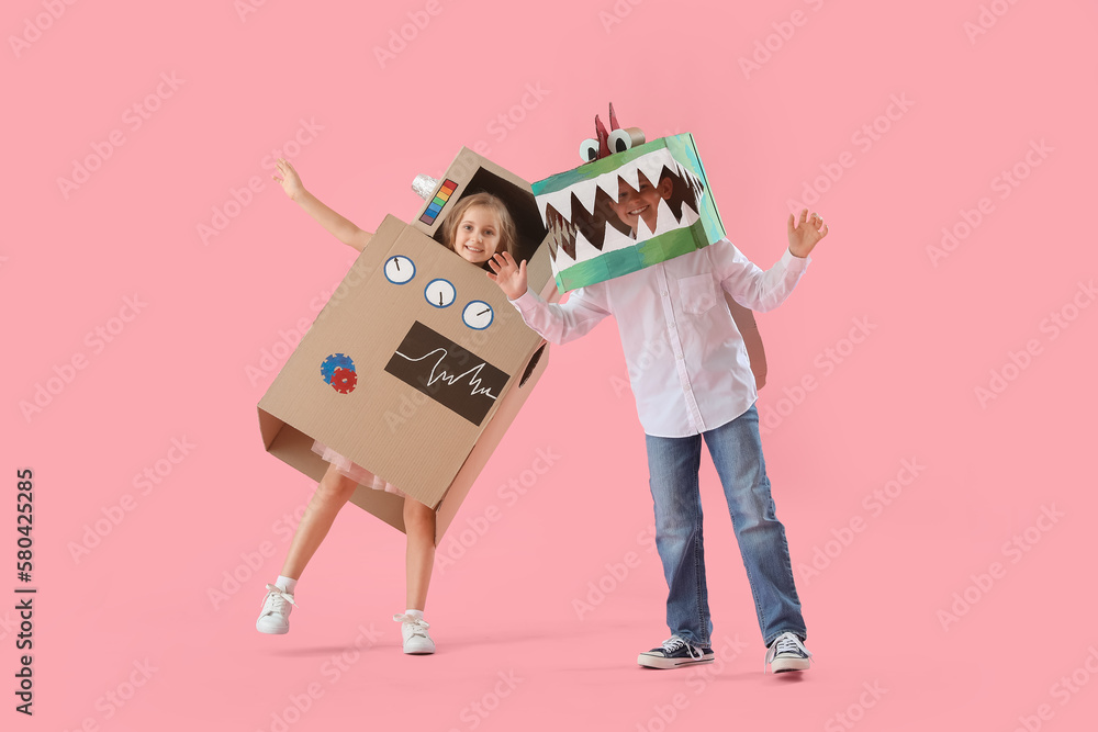 Little children in cardboard costumes on pink background