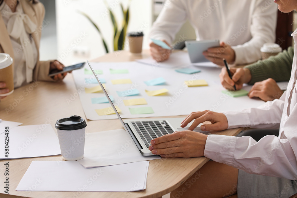 Group of people with sticky notes working on business plan at table in office, closeup