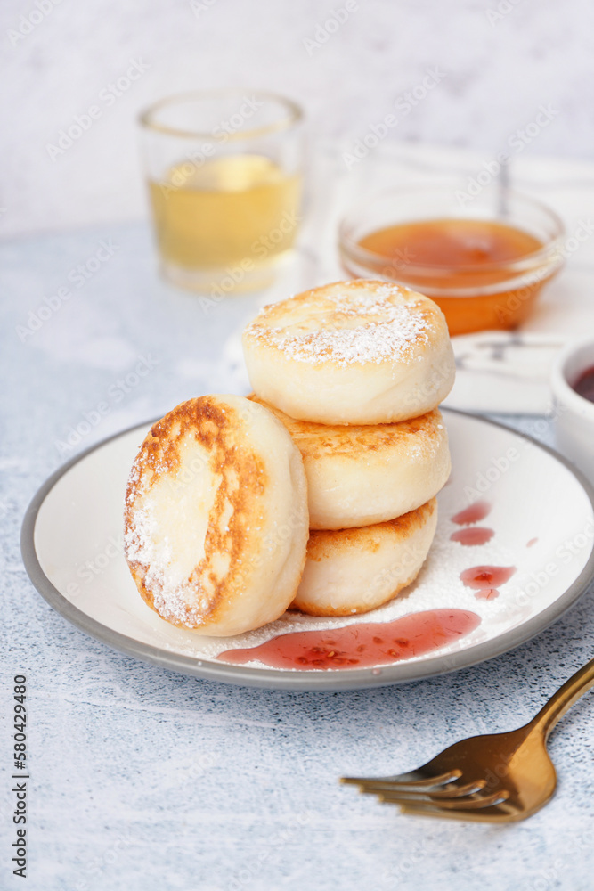 Plate with delicious cottage cheese pancakes on light background, closeup