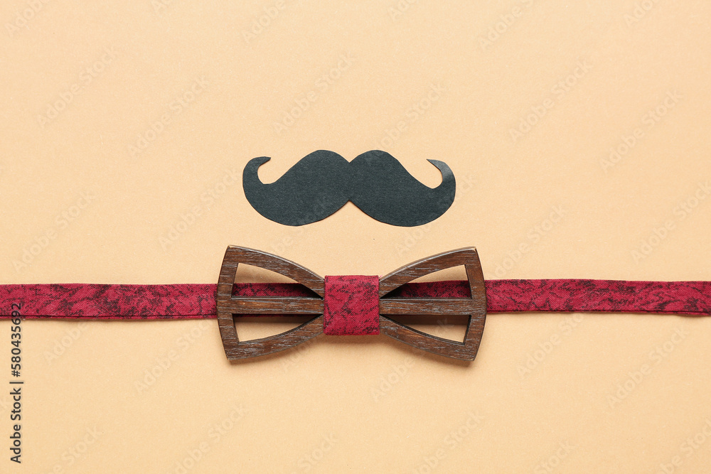 Composition with stylish wooden bow tie and paper mustache on color background