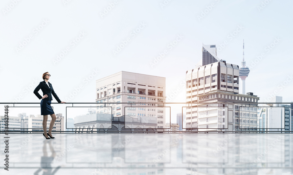 Sunrise above skyscrapers and businesswoman facing new day