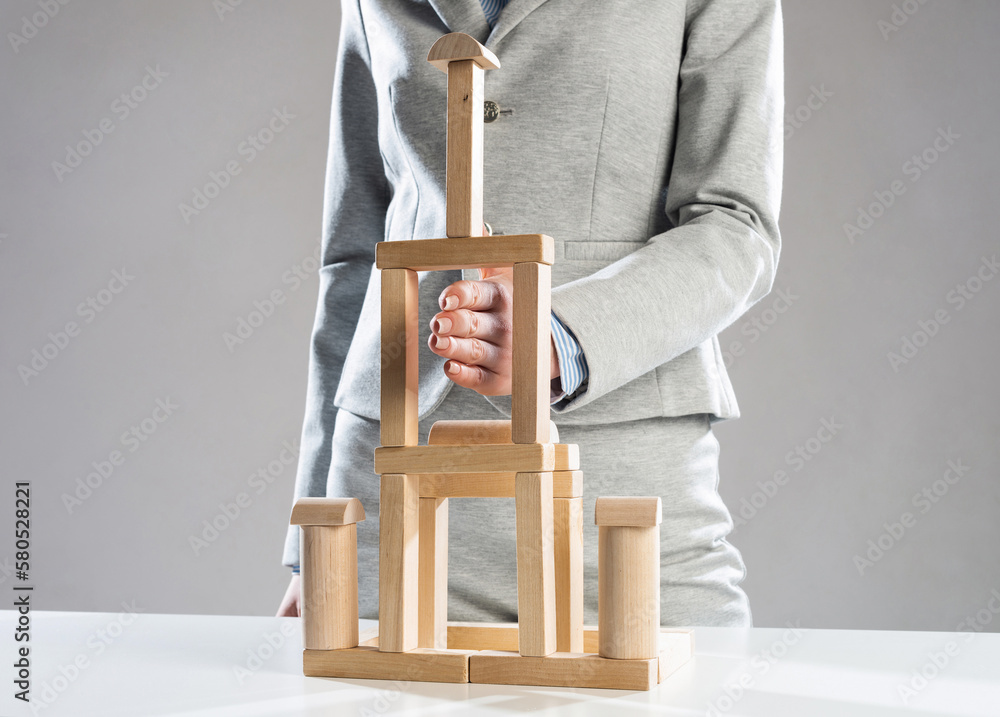 Business woman building tower on table