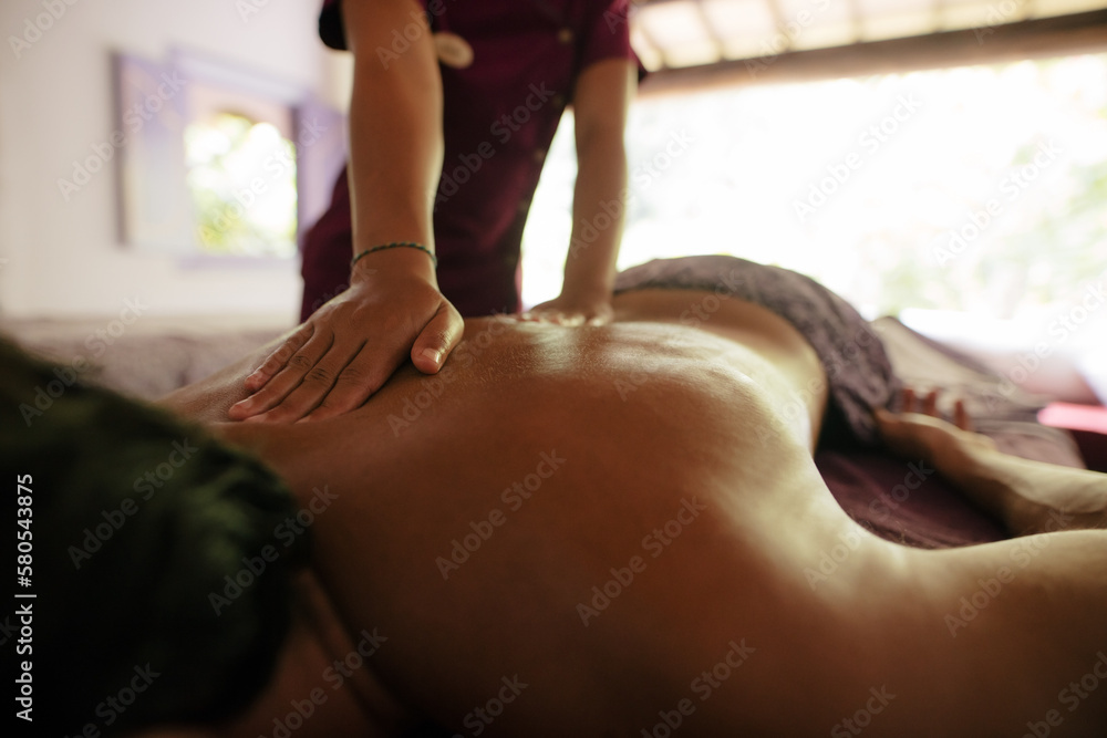 Female therapist massaging man at health spa