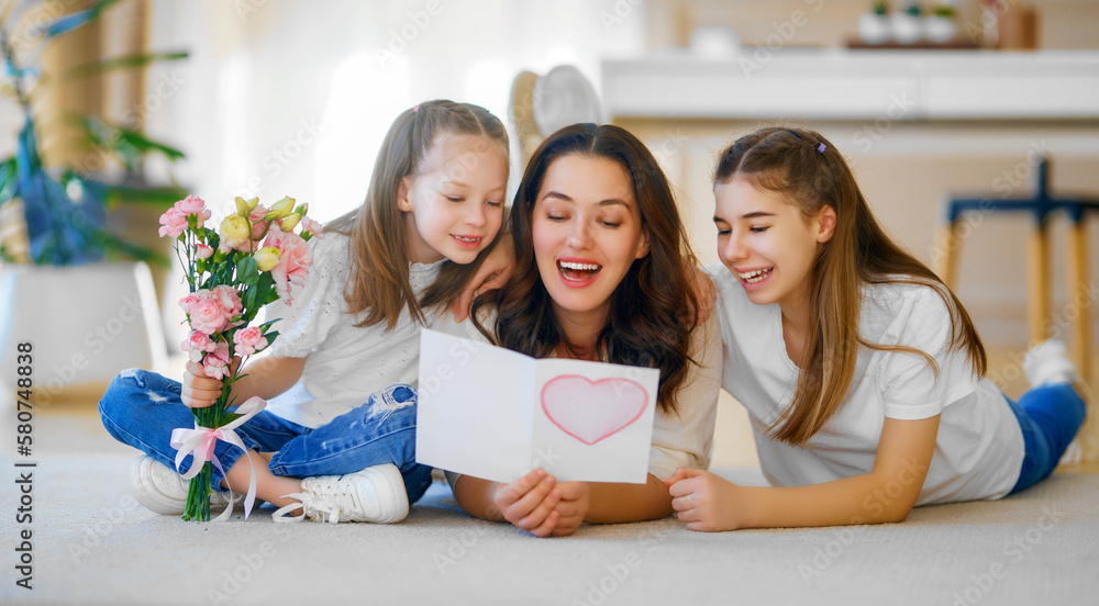 Daughters giving mother bouquet of flowers.