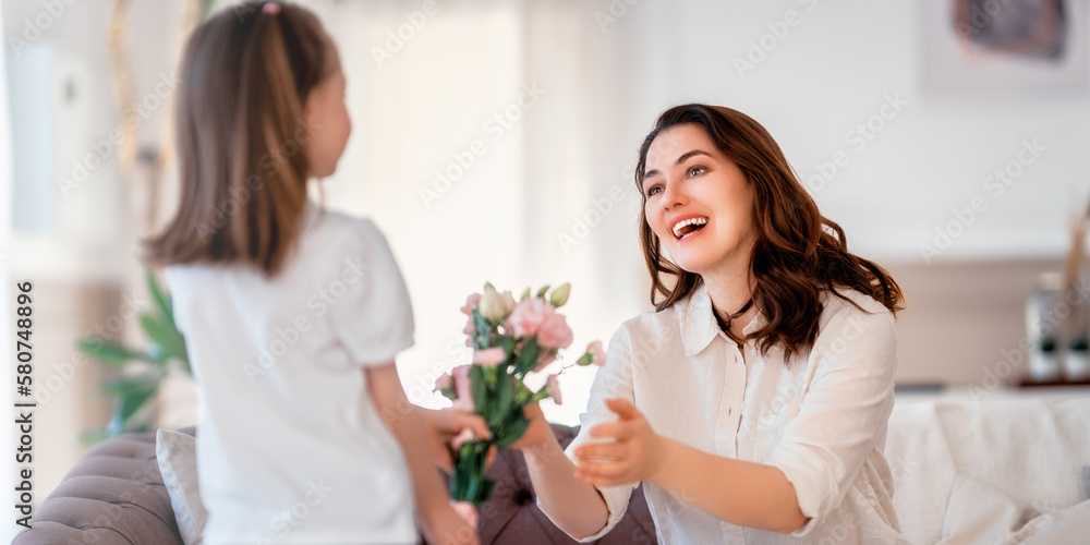 Daughter giving mother bouquet of flowers.