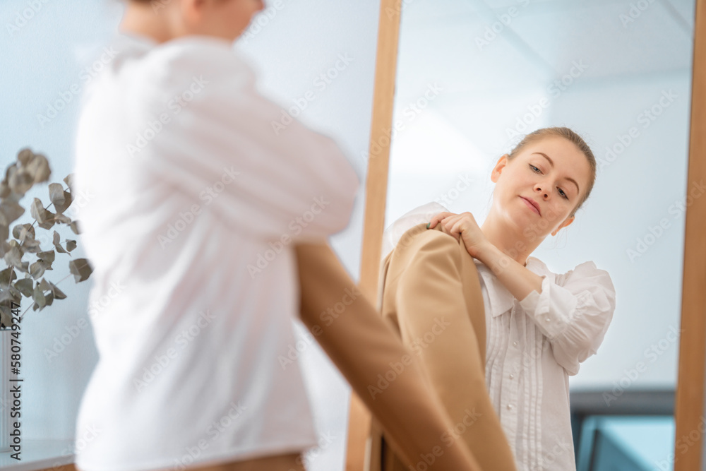 woman looking at her reflection in mirror