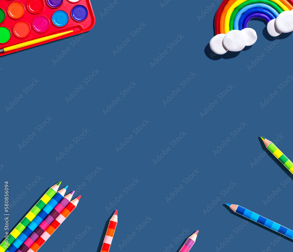 Art supplies with a rainbow - overhead view - flat lay