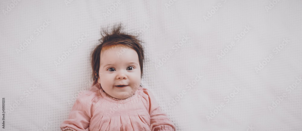 Cute little baby lying on the white blanket.