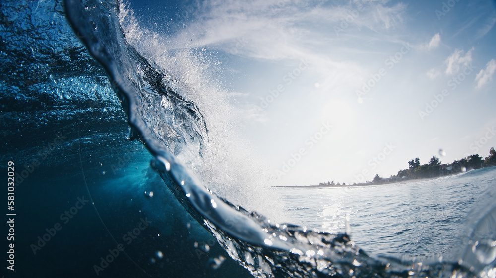 Crystal clear ocean wave breaks on the shore in the Maldives