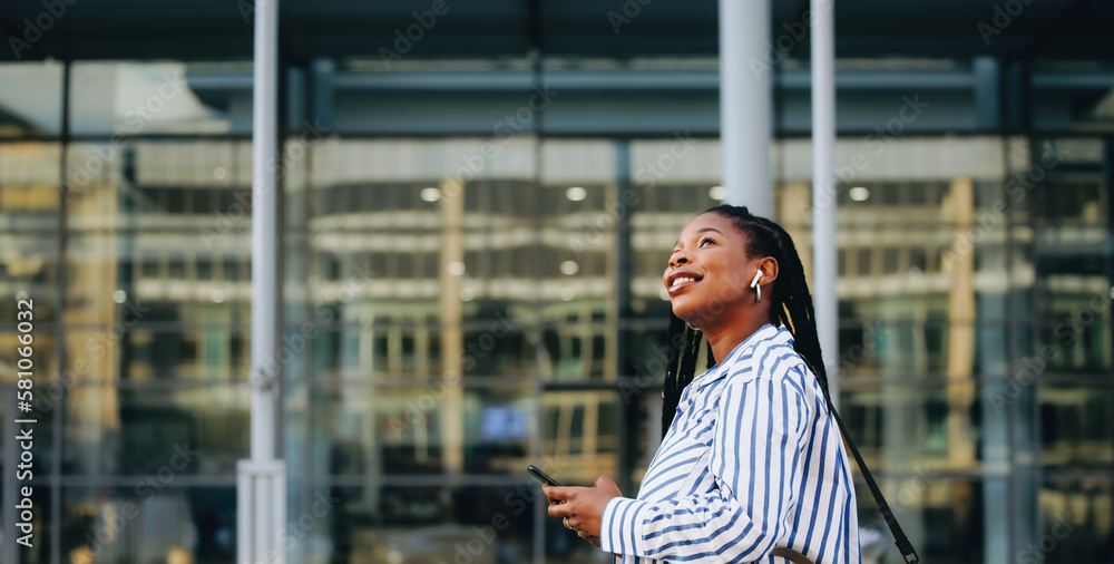 Sideview of a young business woman using a smartphone while commuting in the city