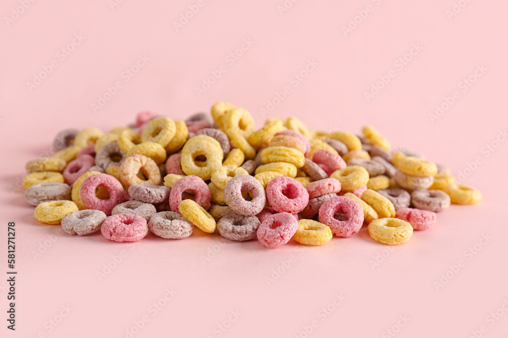 Heap of colorful cereal rings on pink background