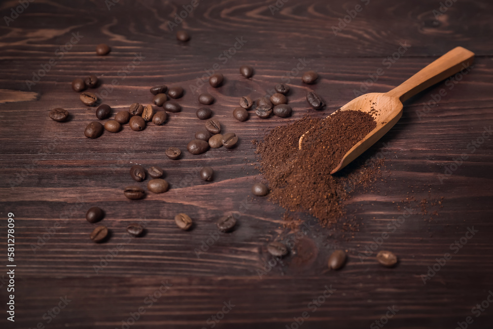 Scoop of coffee powder and beans on dark wooden background