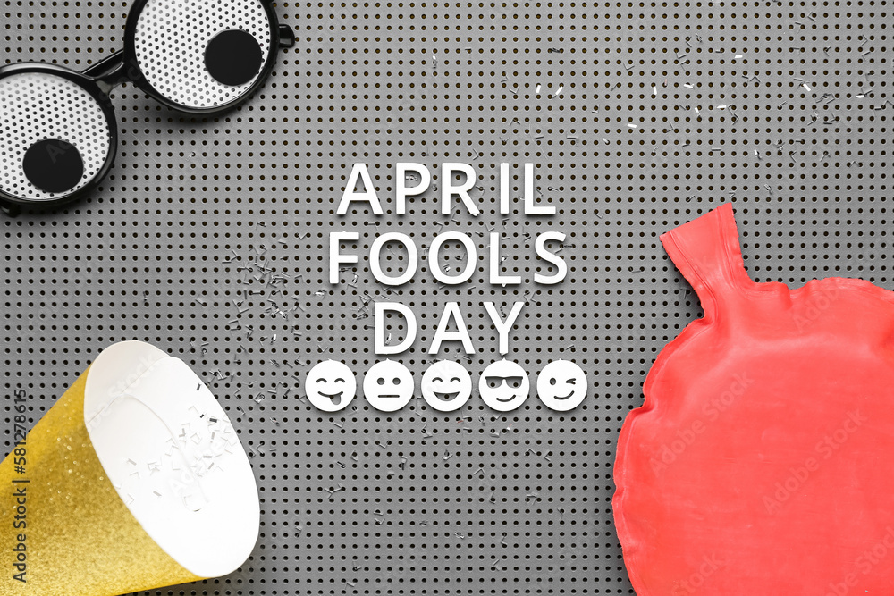 Text APRIL FOOLS DAY, funny decor and party hat on board