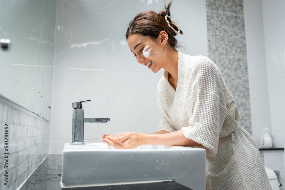 Asian beautiful woman washing her clean face with facial foam and water. 