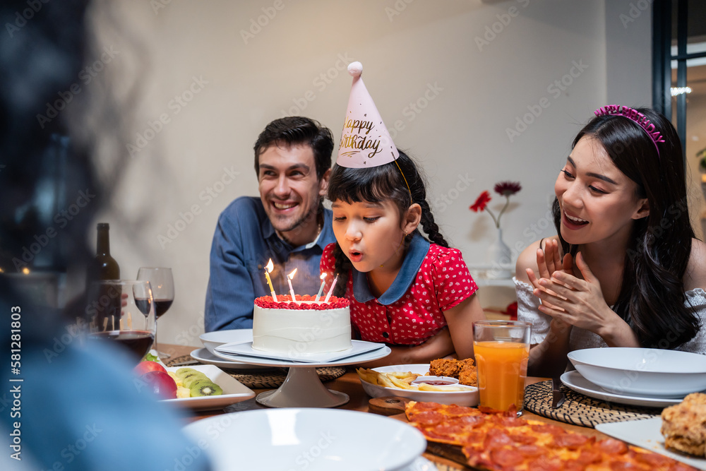 Multi-ethnic big family having a birthday party for young kid daughter. 