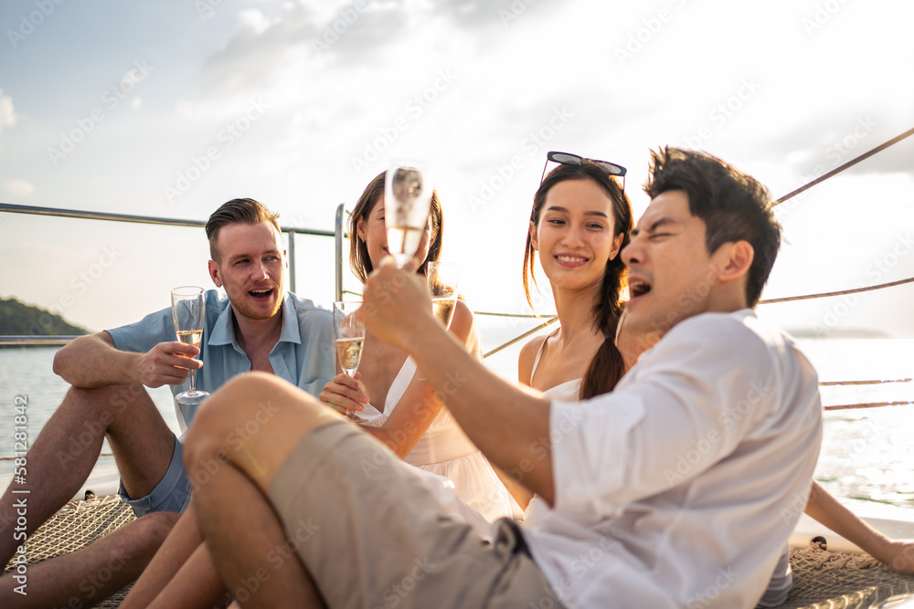 Group of diverse friends drink champagne while having a party in yacht. 