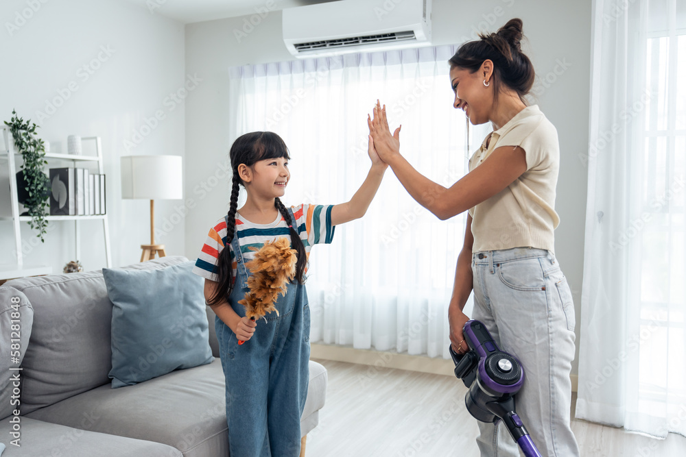 Caucasian beautiful mother cleaning house with young kid daughter. 