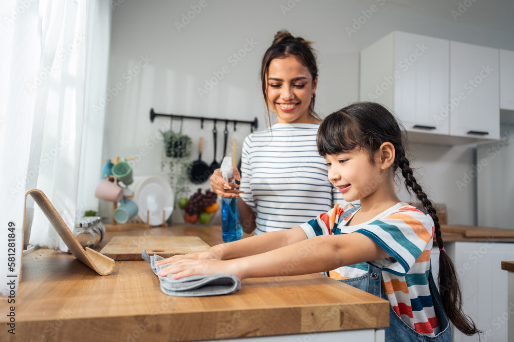 Caucasian beautiful mother cleaning house with young kid daughter. 