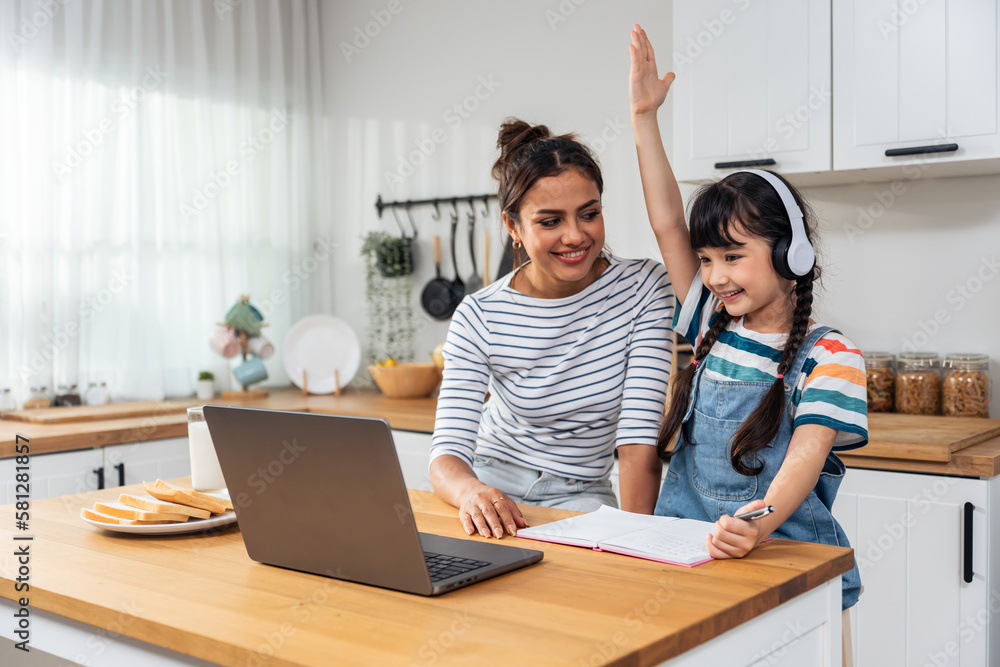 Caucasian young girl kid learning online class at home with mother. 