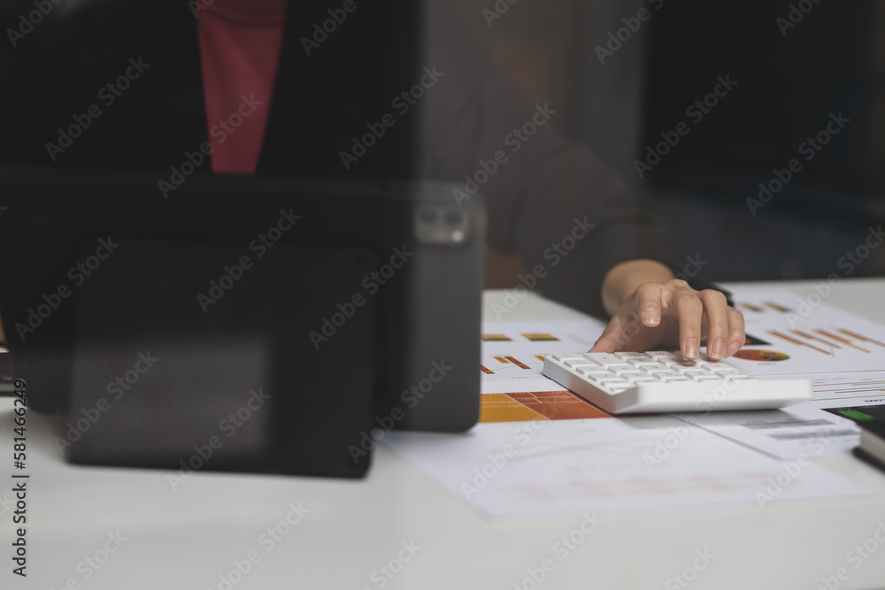 Businesswoman working with tablet analyzing investment market and calculating accounting.