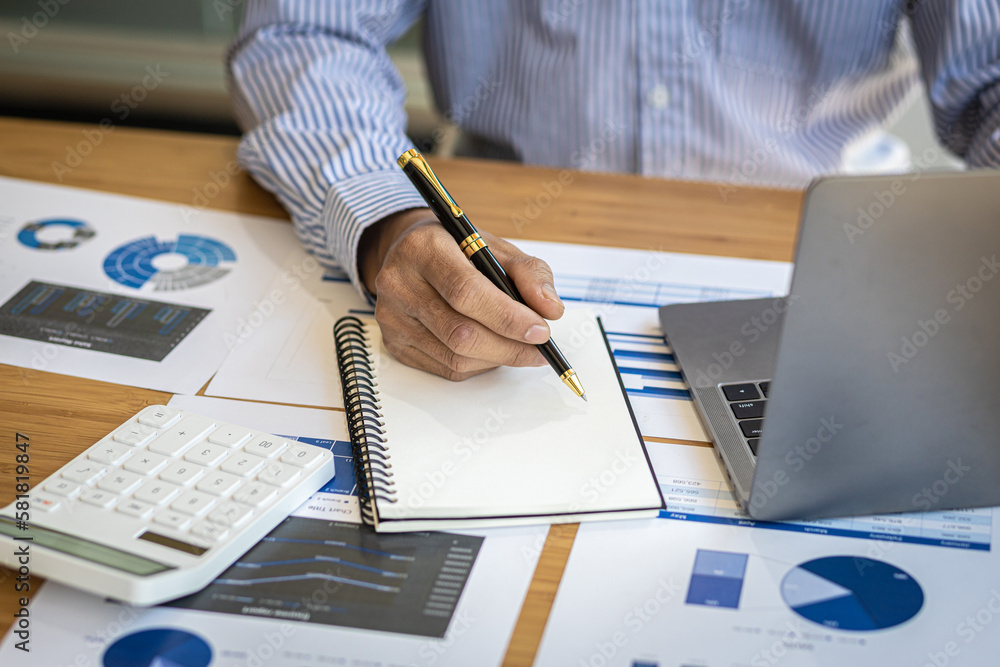 Businessman working with laptop and analyzing financial document data for budget accounting.