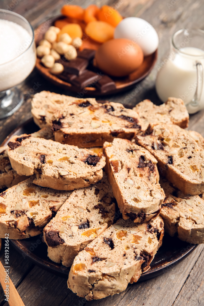 Plate with delicious biscotti cookies on wooden background