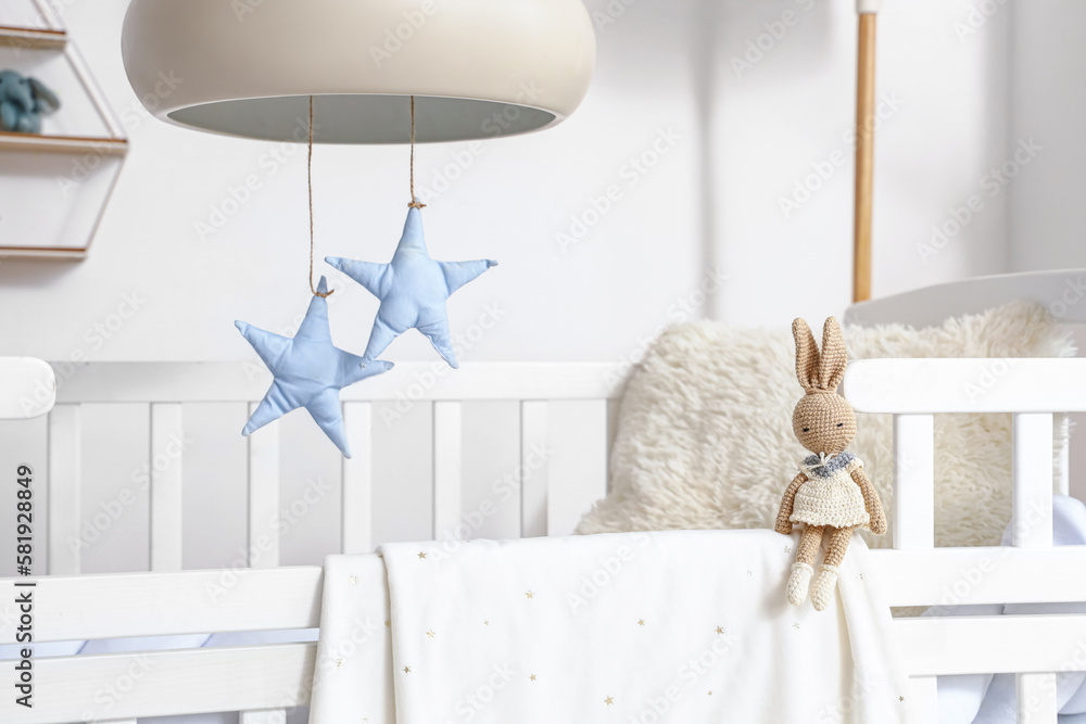 Baby crib with toy bunny in bedroom, closeup