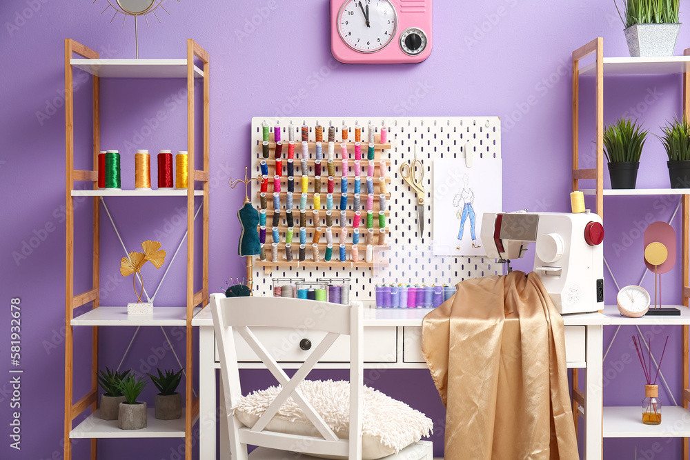 Interior of atelier with tailors workplace, thread spools and shelving units