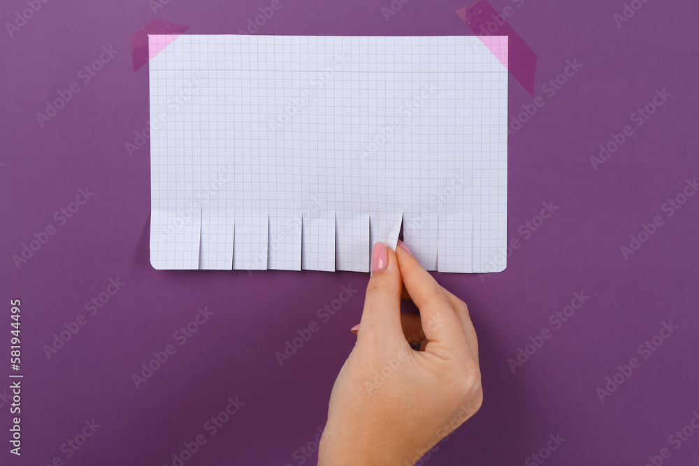 Woman tearing off paper ad on purple background