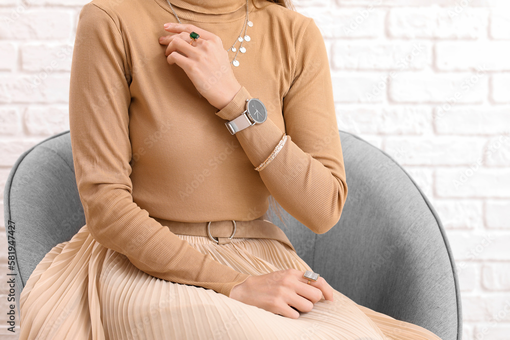 Woman with stylish wristwatch sitting at home, closeup