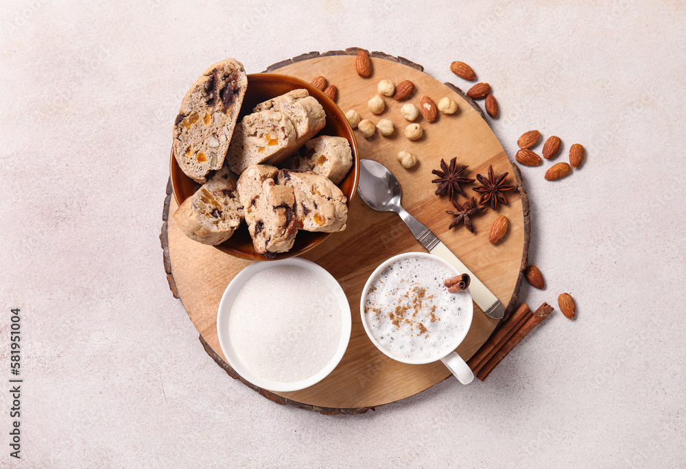 Board with delicious biscotti cookies, nuts and cup of coffee on white background